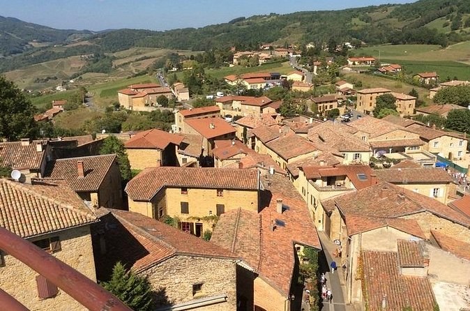 The tiled roofs and golden-stone houses of a hill village seen from above